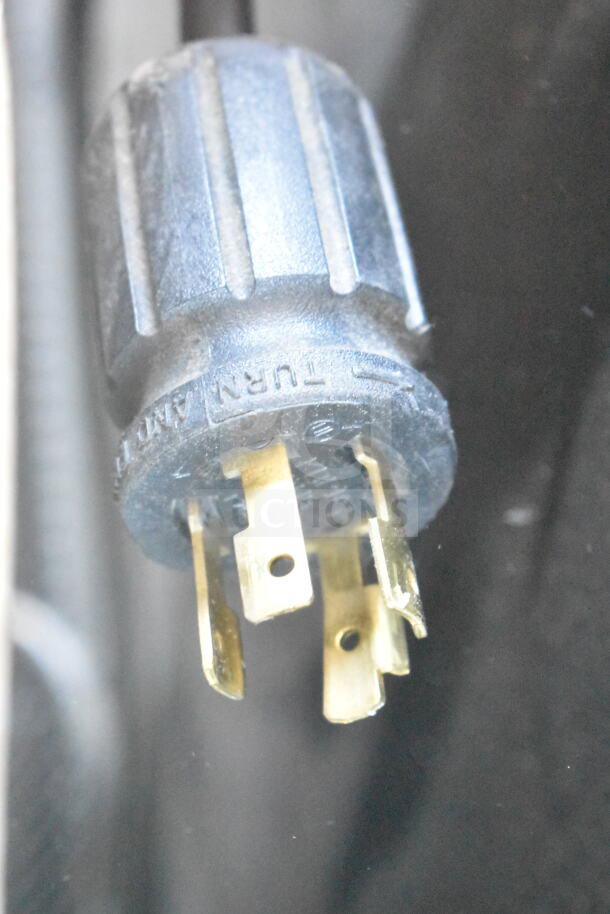 Close-up of a plug for a 2018 True GDM-72F-HC commercial freezer. Features three-pronged design.