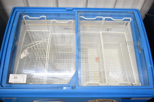 Commercial chest freezer merchandiser on casters, blue exterior, glass top, 115V, 1 phase, wire baskets inside.
