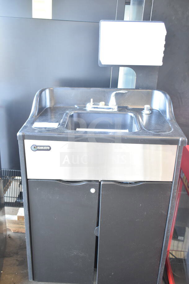 Ozark River portable sink on commercial casters, features stainless steel basin, dual cabinet doors, clean condition.