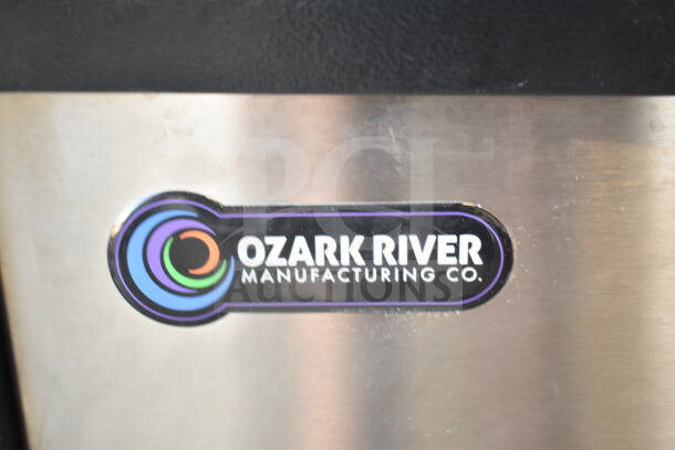 Ozark River Portable Sink label on stainless steel surface, featuring company logo; item on commercial casters.