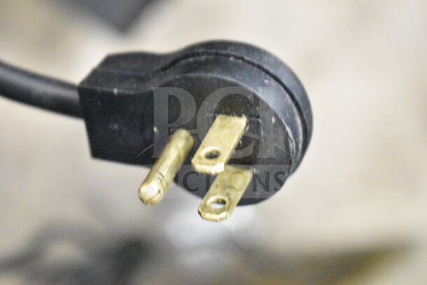 Close-up of a three-prong power plug, black casing, for an Imbera VR12 Commercial Cooler, 115 Volts, 1 Phase.