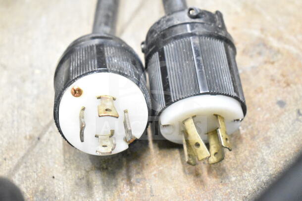 Close-up of two electrical plugs for a Taylor 754-33 ice cream machine, showing prongs and black casings.