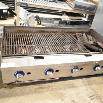 Globe commercial countertop gas charbroiler grill with four knobs, stainless steel body, used condition, visible wear.