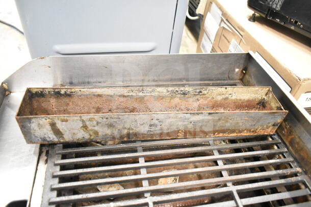 Globe Commercial Countertop Gas Charbroiler Grill with worn grates and rusted drippings tray, indicating used condition.