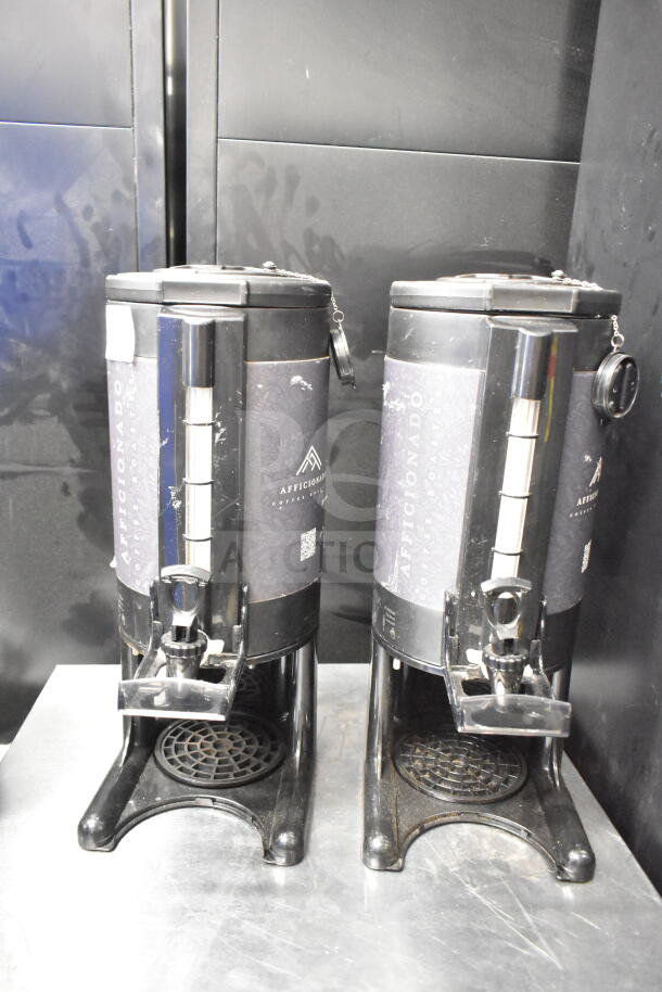 Two Afficionado countertop beverage dispensers; black with silver spout, branded label, and drip tray; fair condition.