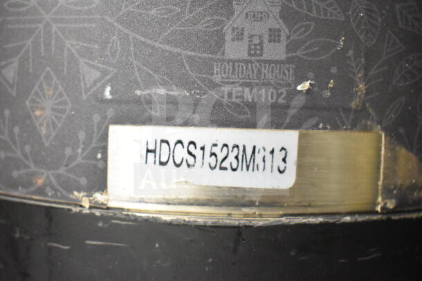 Close-up of a label on 2 countertop beverage holder dispensers, model HDCS1523M813, from Holiday House, in used condition.