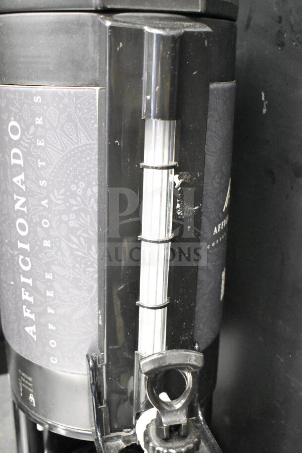 2 Luxus countertop coffee holder dispensers with Aficionado Coffee Roasters branding, featuring a black and clear design.