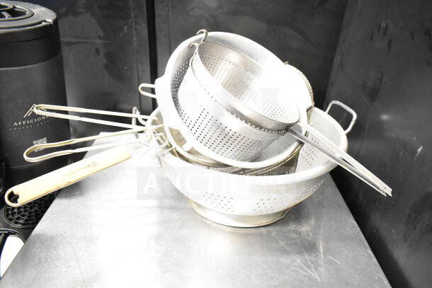 Eight kitchen items including colanders and strainers, metal construction, stackable, gently used condition.