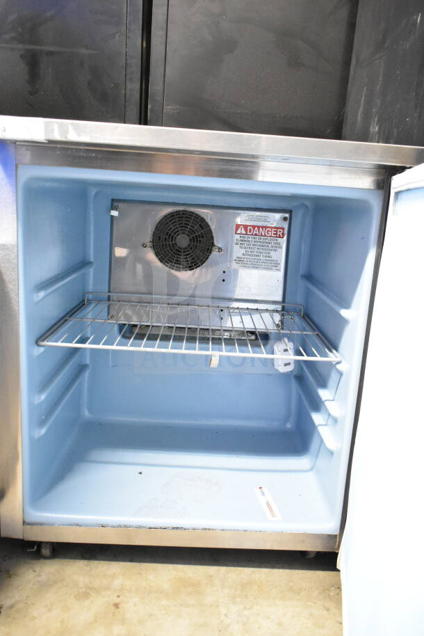Delfield commercial single door undercounter cooler, interior view, 115 volts, 1 phase, visible warning label.