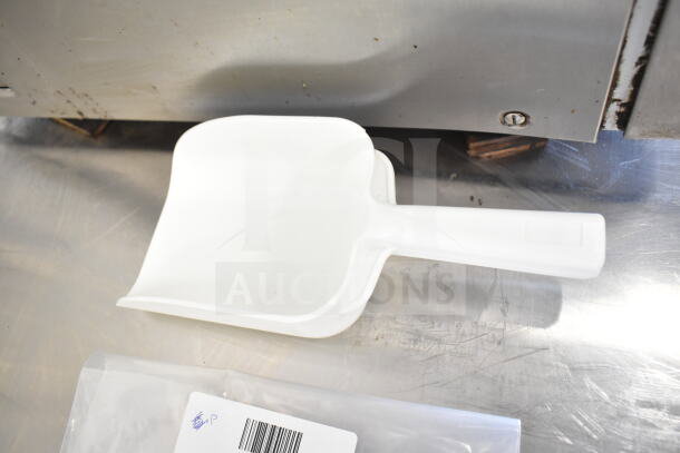 White plastic scooper, new condition, with barcode label on package. Part of an auction item set.