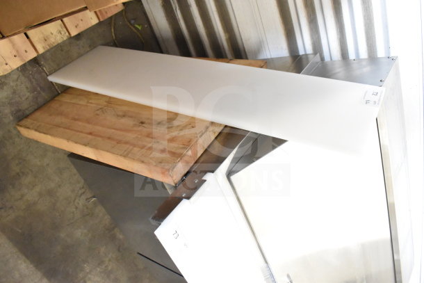 Two cutting boards, one wooden and one plastic, in used condition. Auction lot label visible.