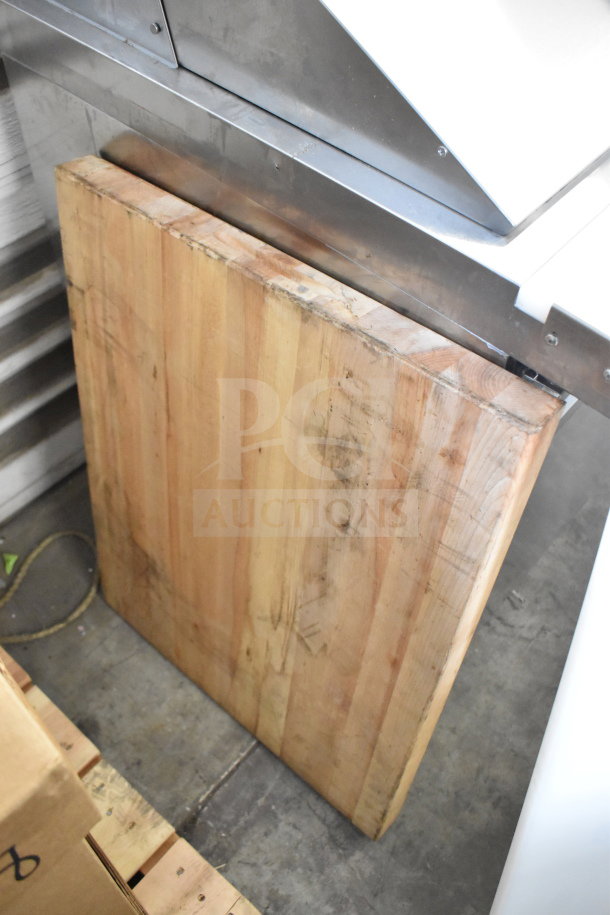 Two wooden cutting boards, varied sizes, well-used condition, placed on the floor, highlighting the wood grain and surface wear.