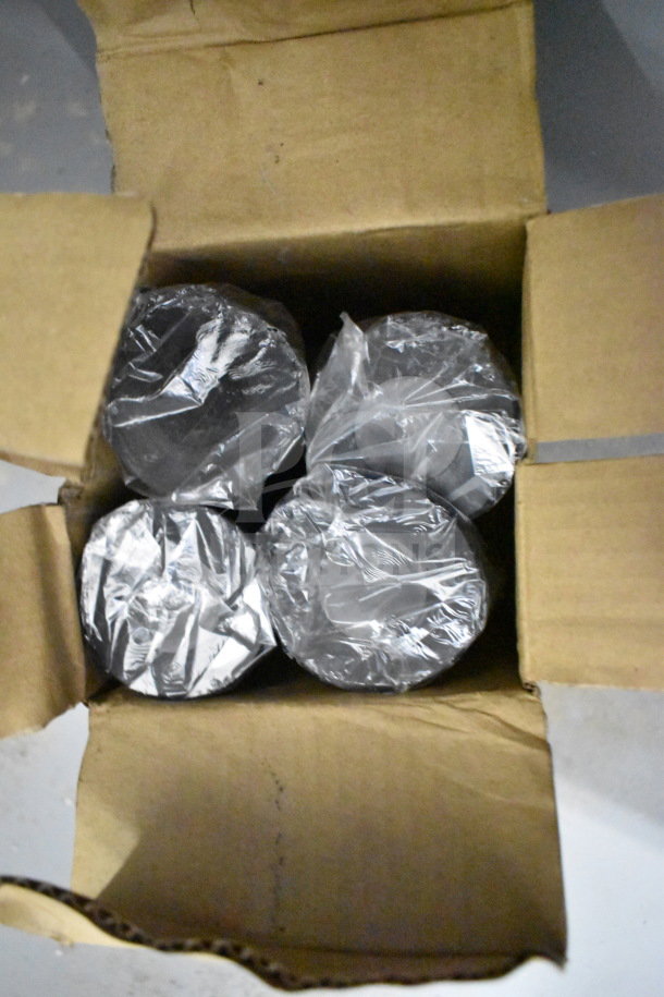 Cardboard box containing four items wrapped in plastic, identifying details not visible.