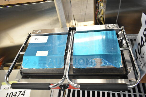 Brand new Avantco 177PG400S commercial dual panini grill with smooth plates, 19 5/8" x 9 1/8" surface, 120V.