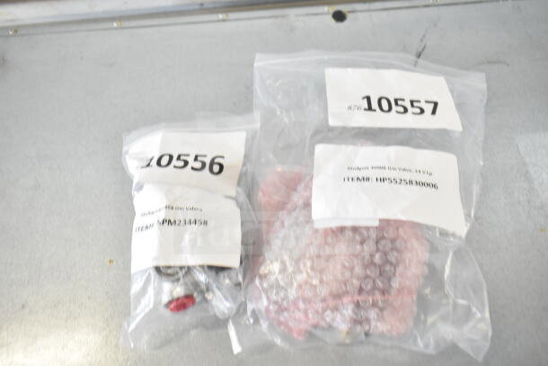 Five brand new scratch and dent heating and cooking components sealed in clear bags with labels showing item numbers 10556 and 10557.