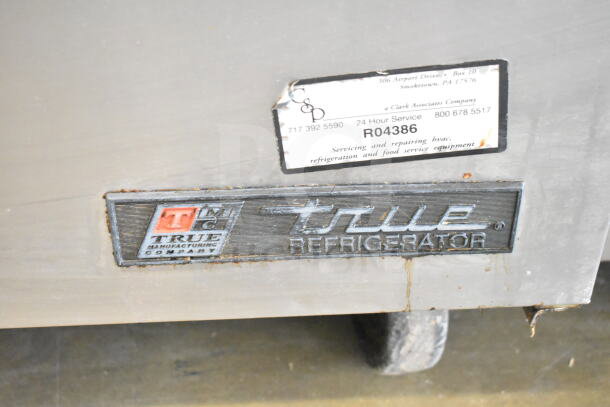 True TUC-72 commercial undercounter cooler with 3 doors, mounted on casters. Power: 115V, 1 phase. Visible wear on surface.
