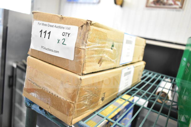 Two boxed Watts 12" wall hydrants, labeled "Brand New Scratch and Dent," with auction details visible on packaging.