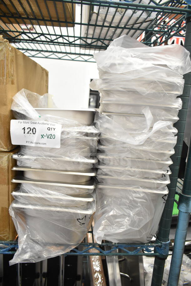 Stack of 20 brand new scratch and dent stainless steel steam table pans, 1/4 and 1/3 sizes, in packaging. Auction lot tag visible.
