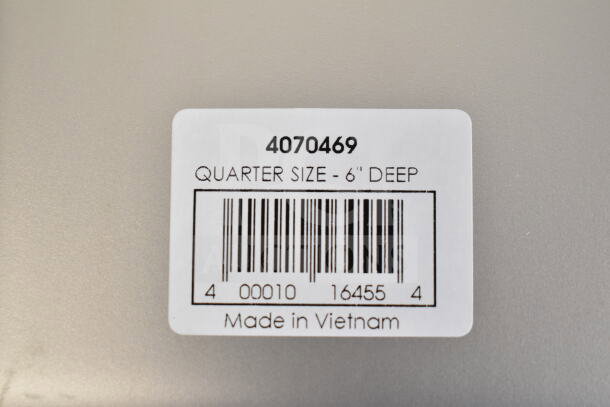 Label on stainless steel steam table pan showing model number 4070469, quarter size, 6" deep, made in Vietnam.