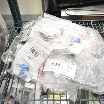 11 new scratch and dent items—including ignition module, sensor, and wiring board—sealed in plastic bags. Model numbers visible.