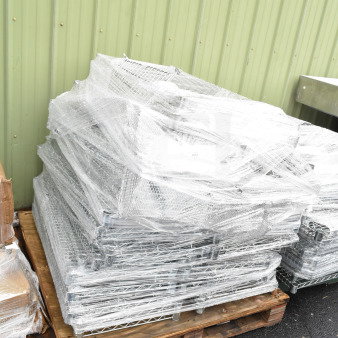 Pallet lot of chrome finish wire shelves wrapped in plastic, stacked for auction. Suitable for storage organization.