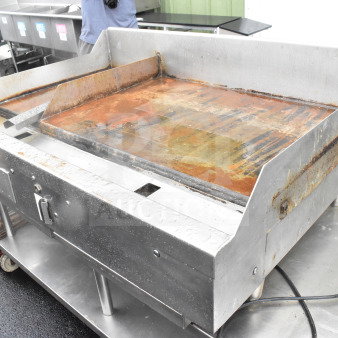 Commercial countertop gas flat top griddle, stainless steel, used condition, visible rust and wear, suitable for large-scale cooking.