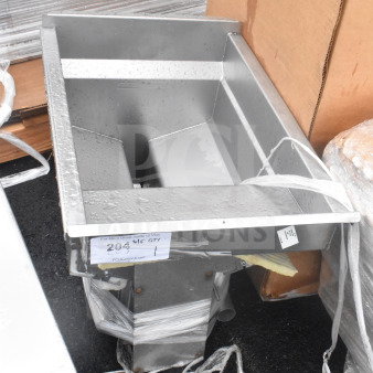 Stainless steel fryer insert, brand new with minor scratches and dents. Cardboard packaging visible. Tag with auction info.