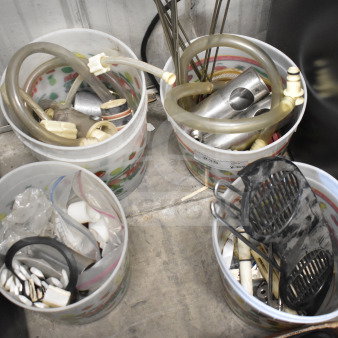 92 various ice cream machine parts in plastic buckets, hoses, and connectors visible. Perfect for maintenance or repairs.