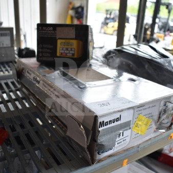 "New Edlund 11100 Manual Can Opener in damaged box, Taylor 5839N Digital Timer box intact, auction items on shelf."