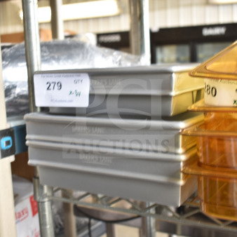 Three brand new Baker’s Lane 1.5 lb 4-strap glazed aluminized steel bread loaf pans, size 10"x5"x3", on a shelf.
