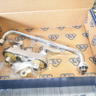 BRAND NEW T&S B-1118 wall-mounted workboard faucet, 4" centers, 12" swing nozzle, in original packaging, minor scratches.