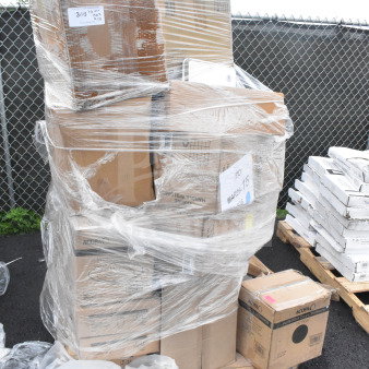 Pallet with boxes of brand new scratch and dent items including a bussing cart and beer glasses, wrapped in plastic. Labels visible.