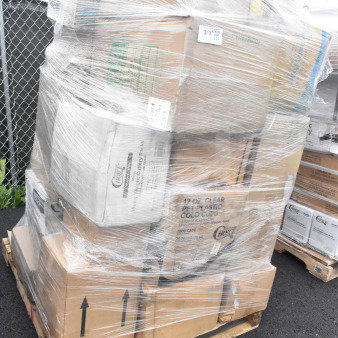 Pallet of 25 scratch and dent items, including napkin bands, pastry bags, and takeout containers, wrapped in plastic.