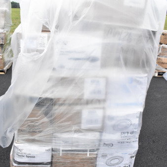 Plastic-wrapped pallet of 32 kitchen items, including portion cups, plates, and napkins. Some boxes marked scratch and dent.