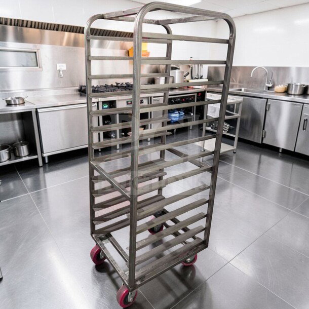 Commercial stainless steel bun pan rack, mobile and heavy-duty, in superior condition with red casters, for bakery use.