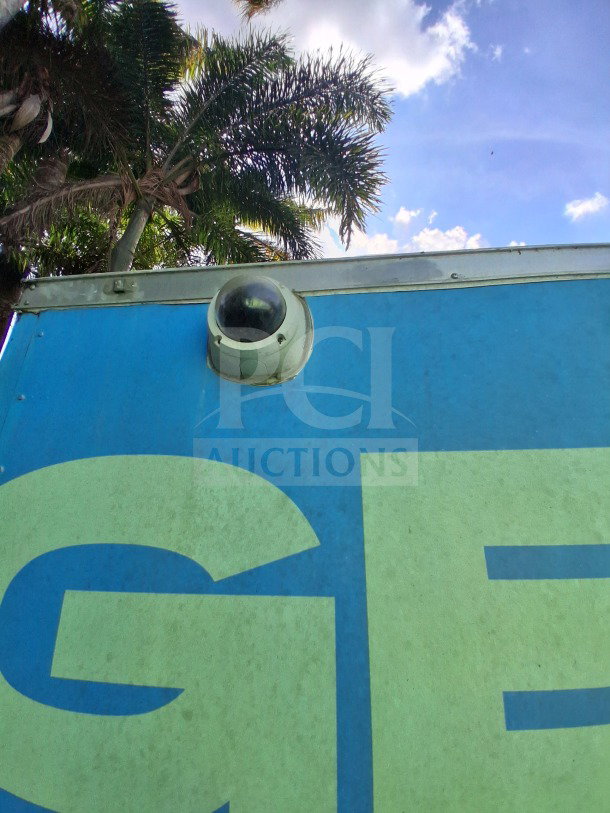 Exterior view of a 2020 Diamond Cargo 24' Custom Mobile Kitchen in blue, featuring surveillance camera, palm trees in background.