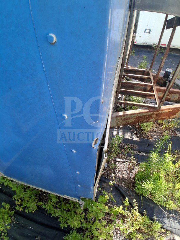 2020 Diamond Cargo 24' Custom Mobile Kitchen, blue wrap, showing exterior corner with rivets and visible wear.