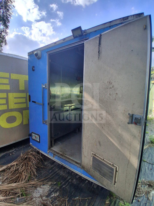 2020 Diamond Cargo 24' mobile kitchen, blue wrap, open door view. Features stainless interior and high-volume cookline.