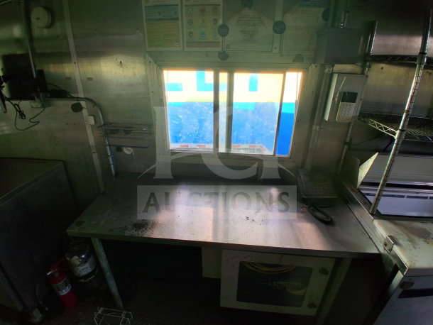 2020 Diamond Cargo 24' mobile kitchen interior with stainless steel surfaces, fire extinguisher, and window.