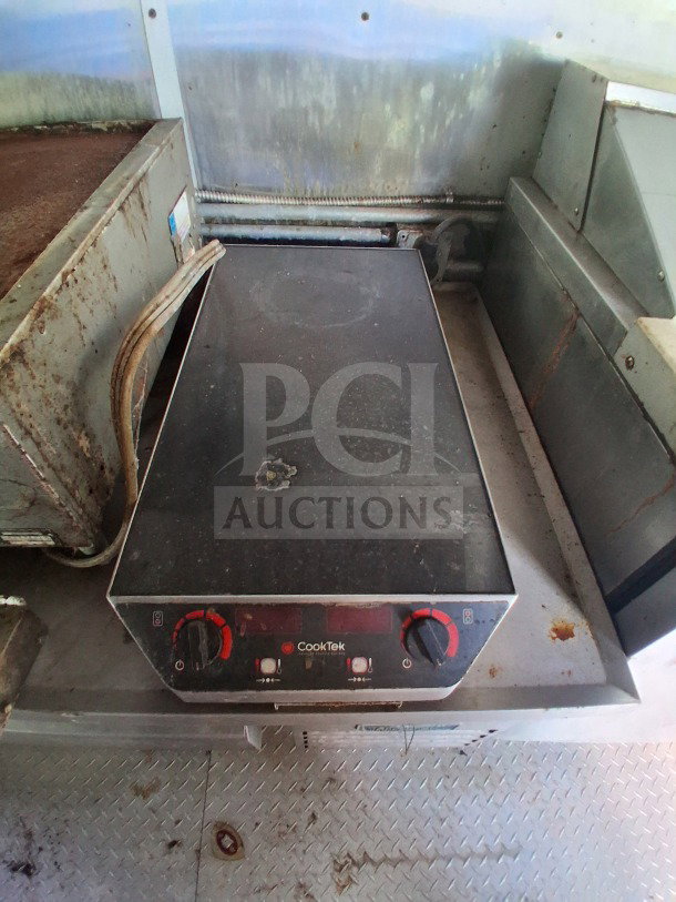 CookTek induction cooktop in a 2020 Diamond Cargo mobile kitchen, showing wear. Stainless steel interior surrounds.