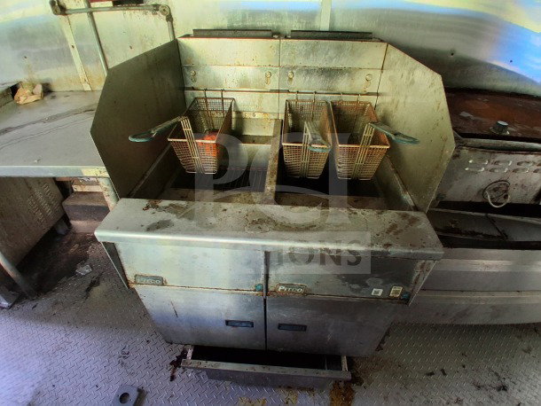 Diamond Cargo mobile kitchen's Pitco deep fryer setup, featuring stainless steel finish, multiple baskets, and visible wear.