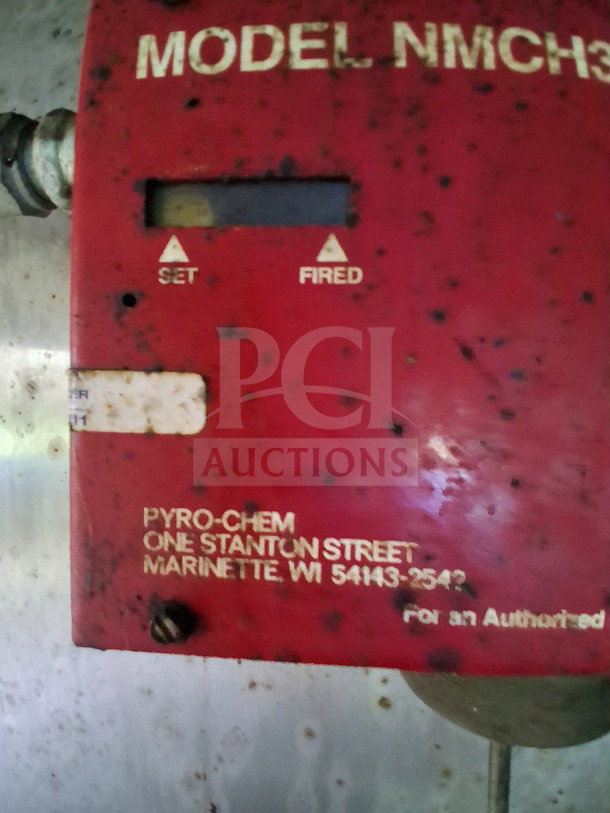 Red Pyro-Chem fire suppression unit with model and location information; part of the mobile kitchen's safety features.