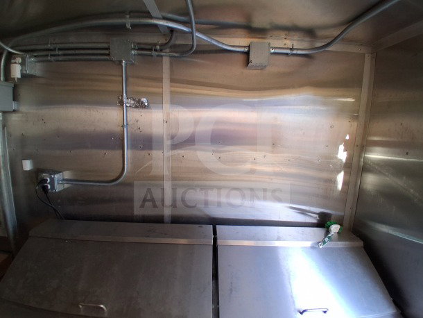Interior view of a 2020 Diamond Cargo 24' Custom Mobile Kitchen with stainless steel walls, wiring, and equipment setup.
