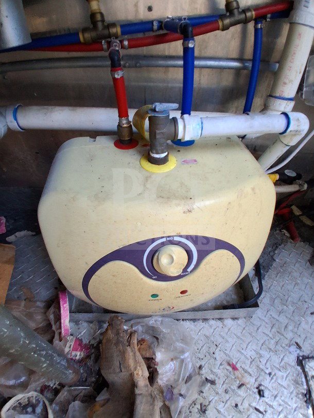 A plumbing component inside the 2020 Diamond Cargo 24' Custom Mobile Kitchen, featuring colored piping.