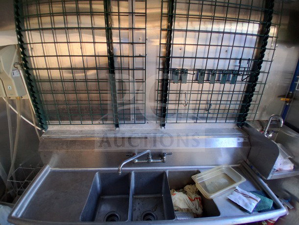 Interior of the 2020 Diamond Cargo 24' Custom Mobile Kitchen, featuring a stainless steel sink and storage area.