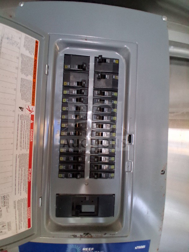 Electrical panel inside 2020 Diamond Cargo 24' Custom Mobile Kitchen, showing multiple circuit breakers and safety labels.