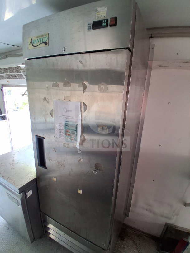Avantco vertical freezer inside a 2019 D&A Custom Food Trailer, featuring stainless steel finish with visible usage marks and refrigeration chart.