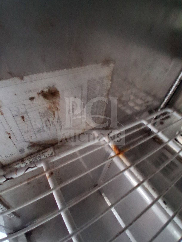 Interior view of the refrigeration unit in a 2019 D&A Custom Mobile Kitchen. Visible are shelving and a partially obscured equipment label.