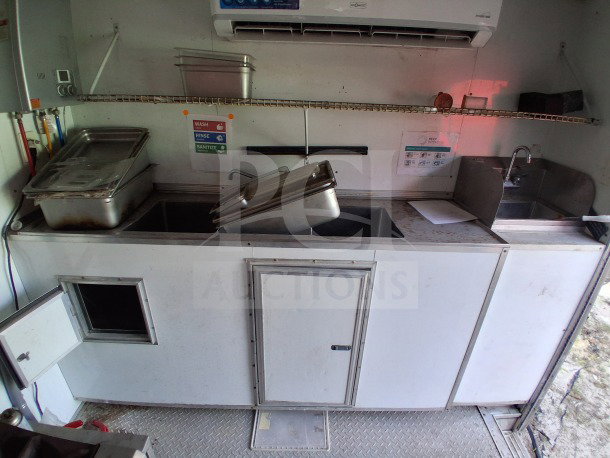2019 D&A Custom 24ft mobile kitchen interior with sinks, prep area, and containers. Features air curtain for comfort.