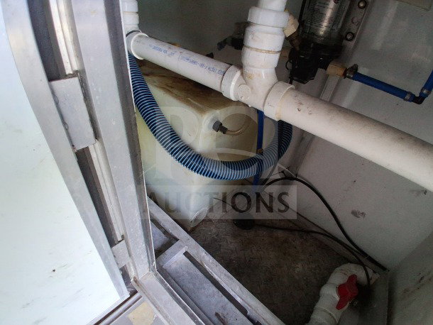 2019 D&A custom mobile kitchen interior under-sink plumbing with drainage pipes and blue hose in fair condition.